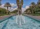 Community entrance with fountain, palm trees, and meticulously maintained landscaping at 27121 Greenfly Orchid Ln, Leesburg, FL 34748