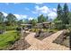 Landscaped backyard featuring brick pathways, charming shed, open carport, and lush greenery under a sunny sky at 28416 Tammi Dr, Tavares, FL 32778