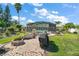 Serene backyard oasis featuring a brick patio, fire pit, grill, and a screened-in pool area at 28416 Tammi Dr, Tavares, FL 32778