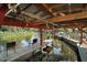 View under a covered boat dock, highlighting seating and a tranquil waterfront setting at 28416 Tammi Dr, Tavares, FL 32778