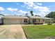 Charming single-story home with a well-manicured lawn, driveway, and an attached two-car garage at 28416 Tammi Dr, Tavares, FL 32778