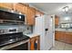 Bright kitchen features stainless steel appliances, tile backsplash, and white cabinetry at 28416 Tammi Dr, Tavares, FL 32778