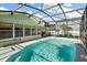 Clear blue swimming pool in a screened enclosure, surrounded by patio space and landscaping at 28416 Tammi Dr, Tavares, FL 32778