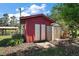 Red shed with double doors complemented by a smaller storage unit, all nestled in a mulch-covered area at 28416 Tammi Dr, Tavares, FL 32778