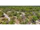 Wide aerial view of a wooded property with mature trees, houses, gravel parking area and other buildings at 331 W Lewis Ave, Apopka, FL 32712