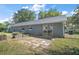 Exterior view of the backyard with patio area, garden, and mature trees at 331 W Lewis Ave, Apopka, FL 32712