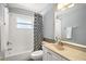 Full bathroom featuring a shower-tub combination, sleek vanity, decorative mirror, and modern fixtures at 331 W Lewis Ave, Apopka, FL 32712