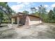 A wooden two-car garage with an open-air extension, showing weathered wood and concrete at 331 W Lewis Ave, Apopka, FL 32712