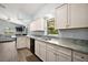Bright kitchen with white cabinets, granite countertops, and stainless steel sink at 331 W Lewis Ave, Apopka, FL 32712