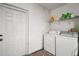 Functional laundry room with washer, dryer, white walls, and shelving at 331 W Lewis Ave, Apopka, FL 32712