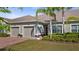 Inviting home exterior featuring a well-manicured lawn, brick driveway, and a two-car garage at 3512 Belland Cir # B, Clermont, FL 34711