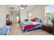 Comfortable bedroom with large window, ceiling fan, and carpeted floors at 3728 Mulberry Grove Loop, Leesburg, FL 34748