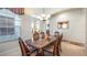 Formal dining room with a chandelier, elegant table setting, and natural light from the window at 3728 Mulberry Grove Loop, Leesburg, FL 34748
