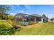 Backyard view of screened-in pool with mature landscaping at 3728 Mulberry Grove Loop, Leesburg, FL 34748
