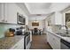 Open floor plan showing modern appliances, granite countertops, and access to the dining area at 3860 Branch Ave, Mount Dora, FL 32757