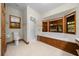 Bathroom featuring shower, toilet and tub with wood trim and scenic window views at 39636 Carolina Ave, Lady Lake, FL 32159