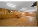 Bonus room with wood paneling, laminate floor, drop staircase, and wall AC unit at 39636 Carolina Ave, Lady Lake, FL 32159