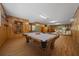 Large game room with wood paneling, laminate floors, pool table, and adjacent sitting area at 39636 Carolina Ave, Lady Lake, FL 32159