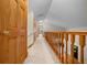 Bright hallway with wood railing, neutral paint, carpet flooring, and multiple doors at 39636 Carolina Ave, Lady Lake, FL 32159