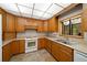 This is a kitchen with wooden cabinets, white appliances, and a tile floor at 39636 Carolina Ave, Lady Lake, FL 32159