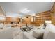 Spacious living room with light wood walls, comfortable seating, and bright overhead lighting at 39636 Carolina Ave, Lady Lake, FL 32159