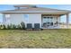 Backyard view of home with patio furniture and sliding glass doors to covered patio at 5397 Marshelder St, Apopka, FL 32712