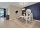 The dining room features a blue accent wall, a modern chandelier, a white table with seating, and access to the outdoor patio at 5397 Marshelder St, Apopka, FL 32712