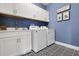 Well-organized laundry room with modern washer, dryer, white cabinets, and eye-catching patterned flooring at 5397 Marshelder St, Apopka, FL 32712