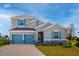Charming two-story home featuring blue shutters, a two-car garage, and a well-maintained lawn at 5481 Marshelder St, Apopka, FL 32712