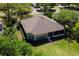 Aerial view of a home highlighting its well-manicured lawn, mature trees, and inviting screened-in lanai at 6106 Spinnaker Loop, Lady Lake, FL 32159