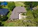 Aerial view of home shows lush landscaping, concrete driveway, and neutral color scheme at 6106 Spinnaker Loop, Lady Lake, FL 32159
