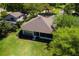 This aerial view captures the home's well-maintained landscaping, inviting screened-in lanai, and proximity to lush greenery at 6106 Spinnaker Loop, Lady Lake, FL 32159