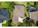 This aerial view shows a property's manicured lawn, screened lanai, and surrounding lush greenery in a serene setting at 6106 Spinnaker Loop, Lady Lake, FL 32159