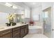 Bright bathroom featuring a double vanity, soaking tub, and glass-enclosed shower at 6106 Spinnaker Loop, Lady Lake, FL 32159