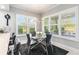 Sunlit dining area featuring a modern glass table with seating for four, offering beautiful views of the landscaped backyard at 6106 Spinnaker Loop, Lady Lake, FL 32159