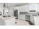 Well-lit kitchen with white cabinets, stainless steel appliances, modern countertops, and an island cooktop at 6106 Spinnaker Loop, Lady Lake, FL 32159