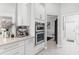 Modern kitchen with stainless steel double ovens, white cabinets, and marble floors at 6106 Spinnaker Loop, Lady Lake, FL 32159