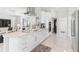 Spacious kitchen with white cabinets, an island cooktop, bar seating, and an open layout to the living room at 6106 Spinnaker Loop, Lady Lake, FL 32159