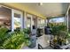 Inviting covered patio with ceiling fans, comfortable seating, and lush plants, perfect for outdoor relaxation and entertaining at 6106 Spinnaker Loop, Lady Lake, FL 32159