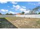 Expansive backyard with a white privacy fence under a blue sky presents a blank canvas for landscaping ideas at 638 Sierra Cir, Davenport, FL 33837