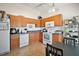 Charming kitchen with wood cabinetry, tiled floor, and modern white appliances, complemented by track lighting at 638 Sierra Cir, Davenport, FL 33837