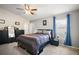 Serene bedroom with ceiling fan, dresser, and large window dressed with blue curtains offering natural light at 638 Sierra Cir, Davenport, FL 33837
