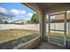 A screened patio offers an outdoor view of the grassy backyard and white privacy fence on a sunny day at 638 Sierra Cir, Davenport, FL 33837