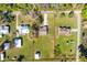 Aerial view of property with a house, a metal building and trees on a sunny day with scattered clouds at 6679 Cr 613, Bushnell, FL 33513