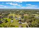 Aerial view of a neighborhood with homes, green lawns, trees, streets and a distant lake and lush greenery at 6679 Cr 613, Bushnell, FL 33513