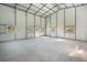 Spacious metal building featuring concrete flooring, a walk-in door, and windows at 6679 Cr 613, Bushnell, FL 33513