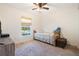 This cozy bedroom has a ceiling fan and a bright window that offers a view of the surrounding landscape at 6679 Cr 613, Bushnell, FL 33513
