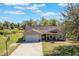 Charming single-Gathering home featuring a two-car garage and a cozy front porch, set on a sprawling lawn with mature trees at 6679 Cr 613, Bushnell, FL 33513