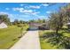 Inviting home with a long driveway, lush green lawn, and a basketball hoop for Gathering fun, all under a bright, sunny sky at 6679 Cr 613, Bushnell, FL 33513