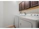 Bright laundry area equipped with a washer and dryer plus overhead cabinets at 6679 Cr 613, Bushnell, FL 33513